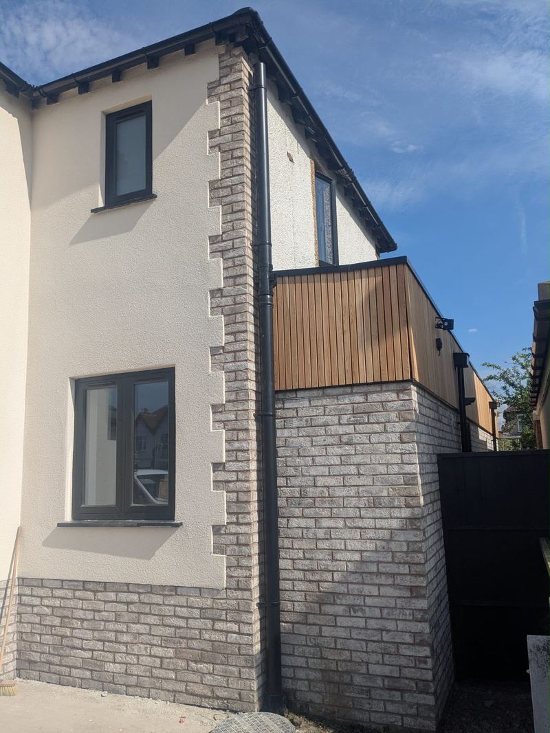 Side elevation finished in coloured render with cedar cladding